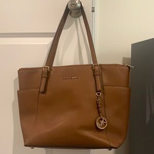 Michael Kors bag brown color it’s real and used but still does it jobs